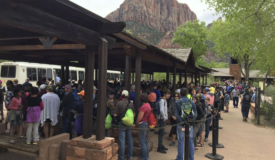 In this Nov. 2016, photo provided by Zion National Park, people line up at Zion National Park, in Utah. The sweeping red-rock vistas at Zion National Park are increasingly filled with a bumper crop of visitors, and now park managers are weighing an unusual step to stem the tide: : Requiring tourists to make RSVPs to get in. (Zion National Park via AP)