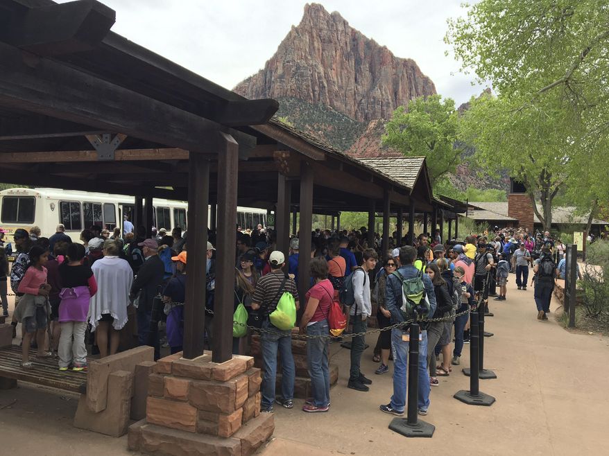 In this Nov. 2016, photo provided by Zion National Park, people line up at Zion National Park, in Utah. The sweeping red-rock vistas at Zion National Park are increasingly filled with a bumper crop of visitors, and now park managers are weighing an unusual step to stem the tide: : Requiring tourists to make RSVPs to get in. (Zion National Park via AP)