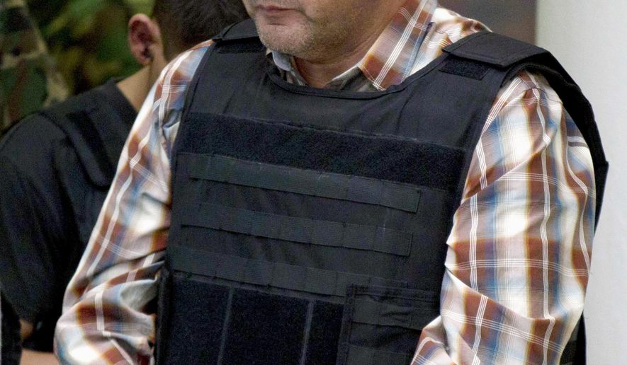 FILE - In this Sept. 27, 2012, file photo, Ivan Velazquez-Caballero, of Nuevo Laredo, Mexico, the alleged leader of the Zetas cartel in Mexico known as "El Taliban," is escorted to a media presentation in Mexico City. Velasquez-Caballero, the former leader of the cartel, must serve 30 years in a U.S. prison and forfeit $10 million for his drug-related crimes after being sentenced Friday, July 21, 2017, by a federal judge in Laredo, Texas. (AP Photo/Eduardo Verdugo, File)