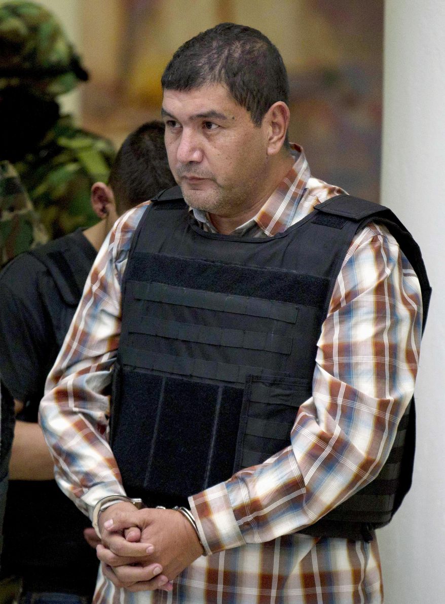 FILE - In this Sept. 27, 2012, file photo, Ivan Velazquez-Caballero, of Nuevo Laredo, Mexico, the alleged leader of the Zetas cartel in Mexico known as "El Taliban," is escorted to a media presentation in Mexico City. Velasquez-Caballero, the former leader of the cartel, must serve 30 years in a U.S. prison and forfeit $10 million for his drug-related crimes after being sentenced Friday, July 21, 2017, by a federal judge in Laredo, Texas. (AP Photo/Eduardo Verdugo, File)