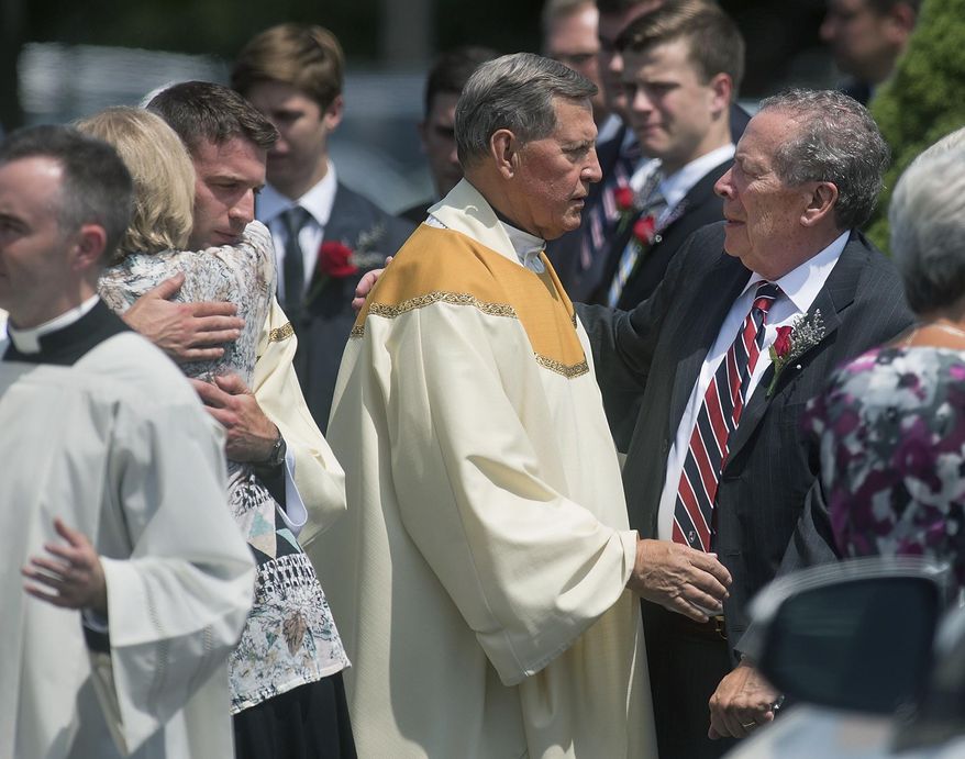 Family members are consoled by clergy after a funeral Mass for Jimi Patrick, of Newtown Township, Pa., at the Church of St. Andrew Friday, July 21, 2017, in Newtown Township, Pa. Patrick was one of four men who were fatally shot and then buried on a Solebury farm owned by the parents of accused killer Cosmo DiNardo, who prosecutors say confessed to the crimes. (Bill Fraser/The Intelligencer via AP)