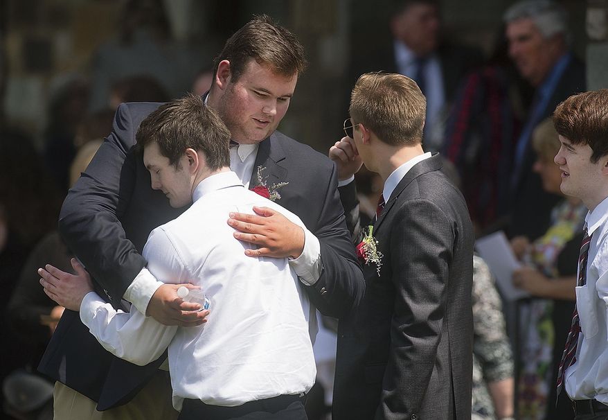 Friends console each other after a funeral Mass for Jimi Patrick, of Newtown Township, at the Church of St. Andrew Friday, July 21, 2017, in Newtown Township, Pa. Patrick was one of four men who were fatally shot and then buried on a Solebury farm owned by the parents of accused killer Cosmo DiNardo, who prosecutors say confessed to the crimes. (Bill Fraser/The Intelligencer via AP)