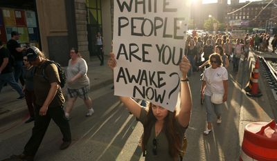 Protesters carry signs as they march against police violence from Loring Park to City Hall, Friday, July 21, 2017, in Minneapolis, Minn.  (Anthony Souffle/Star Tribune via AP)