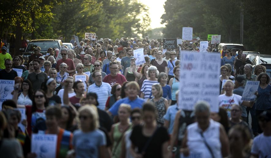 Hundreds march from the site of Justine Damond's shooting to Beard's Plaissance Park during a march in honor of Damond Thursday, July 20, 2017, in Minneapolis. Damond, of Australia, was shot and killed by a Minneapolis police officer on Saturday, July 15 after calling 911 to report what she believed was a possible assault. (Aaron Lavinsky /Star Tribune via AP)