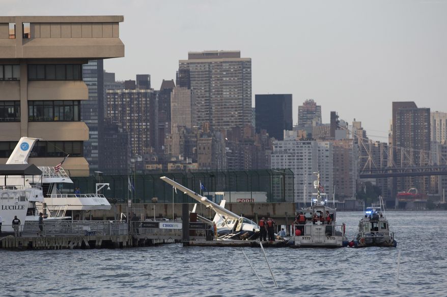 Emergency responders attend to a seaplane that made a hard landing during a failed takeoff along FDR Drive on Friday, July 21, 2017, in New York. (AP Photo/Kevin Hagen)