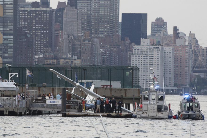 Emergency responders tend to a seaplane that made a hard landing during a failed takeoff along the FDR Drive on Friday, July 21, 2017, in New York. (AP Photo/Kevin Hagen)