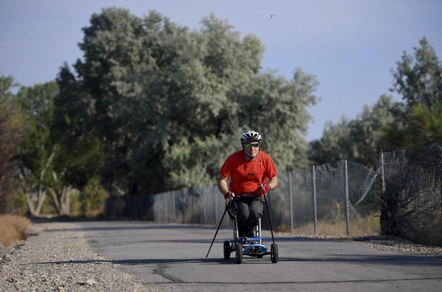 Kevin Hoyt rolls along as he exercises using a paraplegic-friendly mountainboard that was adapted for his use Saturday, July 8, 2017 along the Jordan River Parkway trail in Saratoga Springs, Utah. (Isaac Hale/The Daily Herald via AP)