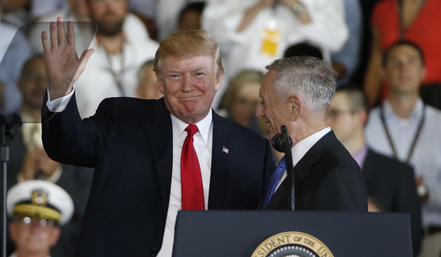 President Donald Trump left, waves to the crowd as he is introduced by Defense Secretary James Mattis, right, aboard the nuclear aircraft carrier USS Gerald R. Ford for it&#39;s commissioning at Naval Station Norfolk in Norfolk, Va., Saturday, July 22, 2017. (AP Photo/Steve Helber)