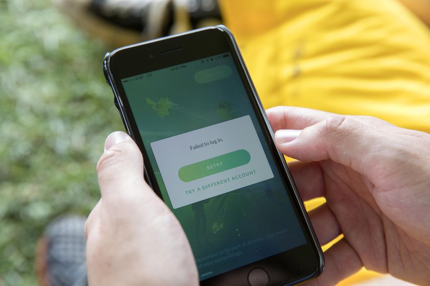 Eric Milovac of Minnesota holds his phone as he waits for a decent Internet connection at the Pokemon Go Fest Saturday, July 22, 2017, in Chicago. Many festival attendees had trouble getting the augmented-reality cellphone game to work. By the afternoon, Mike Quigley, chief marketing officer of the game's developer, Niantic, announced all ticket holders would receive refunds and be issued $100 in credits for use in the app. (Erin Hooley/Chicago Tribune via AP)