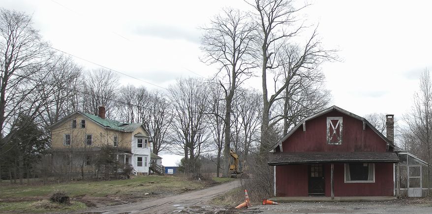 This Friday, April 7, 2017 photo shows the former Ives homestead, left, and barn on the former Chapman property next to Bartlem Park in Cheshire, Conn. The cleanup of a property purchased by Cheshire could include the demotion of the 19th century home that preservationists describe as one of the town’s last examples of a Victorian farmhouse. (Dave Zajac/Record-Journal via AP)