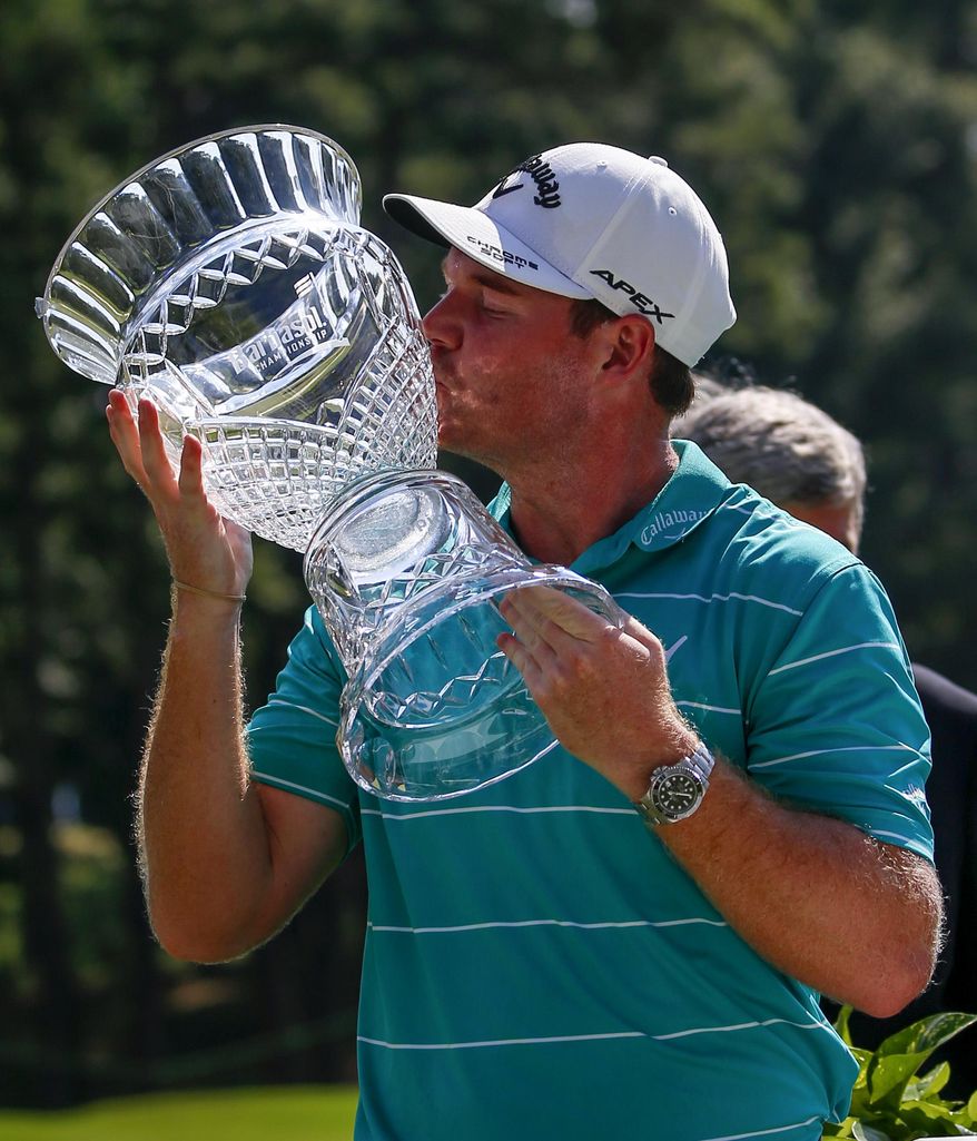 Grayson Murray celebrates by kissing the trophy after winning the Barbasol Championship golf tournament, Sunday, July 23, 2017, in Opelika, Ala. (AP Photo/Butch Dill)