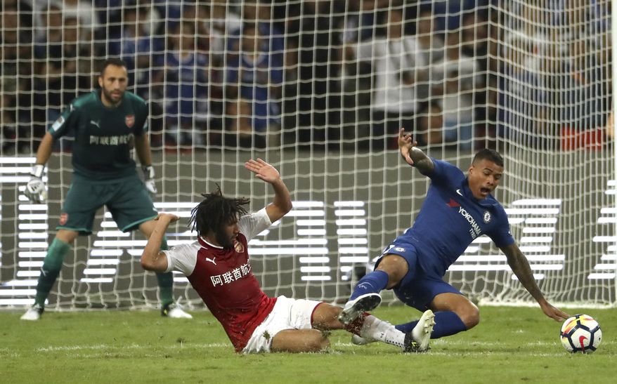 CAPTION CORRECTS THE NAME - Arsenal's Mohamed El Neny, left, tackles Chelsea's Kenedy during the second half of their friendly soccer match in Beijing, Saturday, July 22, 2017. Chelsea beat Arsenal 3-0. (AP Photo/Mark Schiefelbein)
