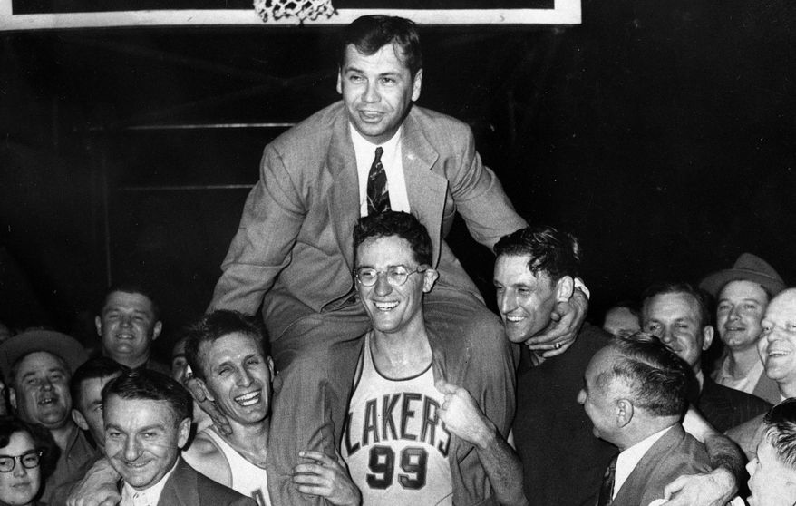 FILE - In this April 25, 1952, file photo, Minneapolis Lakers coach John Kundla, top, is carried by his players to their dressing room in Minneapolis after defeating the New York Knickerbockers to win their fourth NBA basketball championship in five years. Hall of Fame coach Kundla died Sunday, July 23, 2017. He was 101. (AP Photo/File)