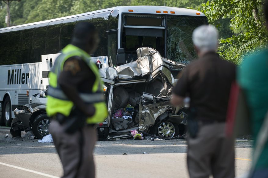 Lieutenant Thomas, left, and Sheriff Brad Swain, right, of the Monroe County Sheriff's Department, look over the wreck of a minivan, in which one man and two women were killed, and passenger bus after a crash involving five vehicles on North State Road 37 just north of Bayles Road in Bloomington, Ind., Saturday, July 22, 2017. (Alex McIntyre/The Herald-Times via AP)