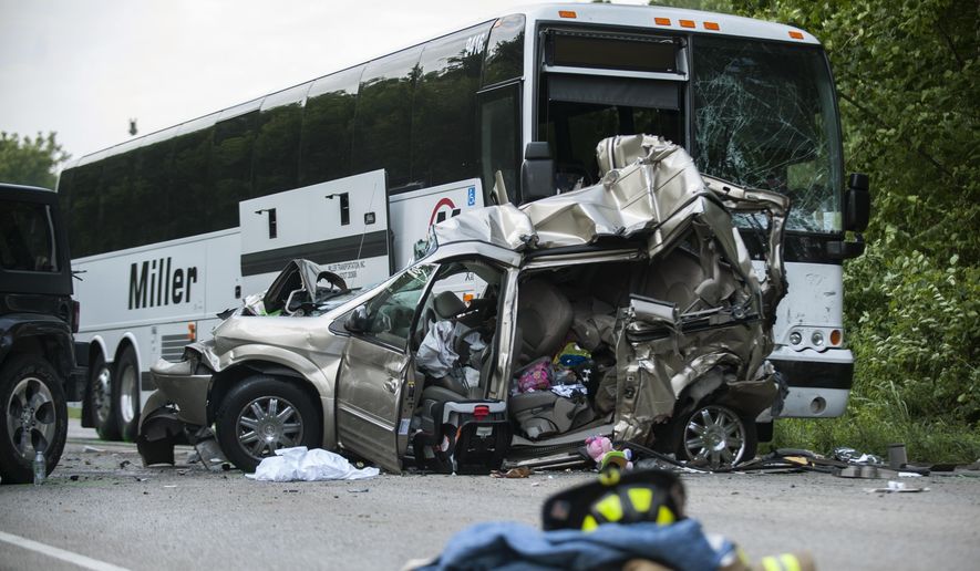 The wreckage of a minivan, in which one man and two women were killed, sits in front of a wrecked passenger bus after a crash involving five vehicles on North State Road 37 Business just north of Bayles Road in Bloomington, Ind. Saturday, July 22, 2017. (Alex McIntyre/The Herald-Times via AP)