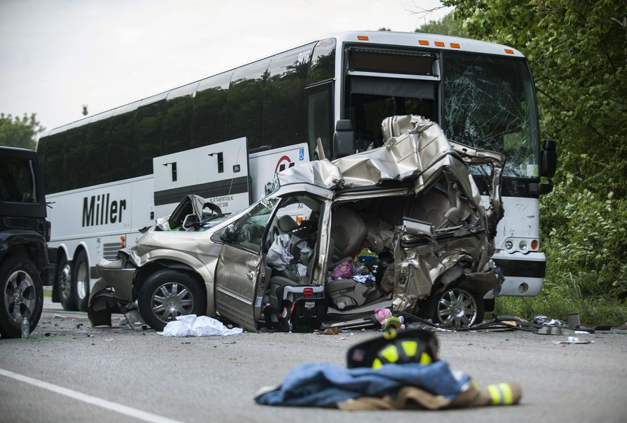 The wreckage of a minivan, in which one man and two women were killed, sits in front of a wrecked passenger bus after a crash involving five vehicles on North State Road 37 Business just north of Bayles Road in Bloomington, Ind. Saturday, July 22, 2017. (Alex McIntyre/The Herald-Times via AP)