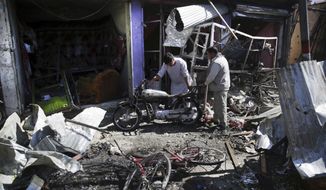Men look at the remains of their properties at the site of a suicide attack in Kabul, Afghanistan, Monday, July 24, 2017. A suicide car bomb killed dozens of people as well as the bomber early Monday morning in a western neighborhood of Afghanistan&#39;s capital where several prominent politicians reside, a government official said. (AP Photos/Massoud Hossaini)