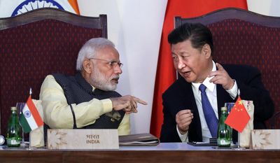 FILE - In this Oct. 16, 2016, file photo, Indian Prime Minister Narendra Modi, left, talks with Chinese President Xi Jinping at a signing ceremony by foreign ministers during the BRICS summit in Goa, India. India and China have faced off frequently since fighting a bloody 1962 war that ended with China seizing control of some territory. India’s army chief warned in July 2017 that India’s army was capable of fighting “2 1/2 wars” if needed to secure its borders. The dispute was discussed briefly without resolution by Xi and Modi on the sidelines of the G-20 summit in Hamburg, Germany. (AP Photo/Manish Swarup, File)