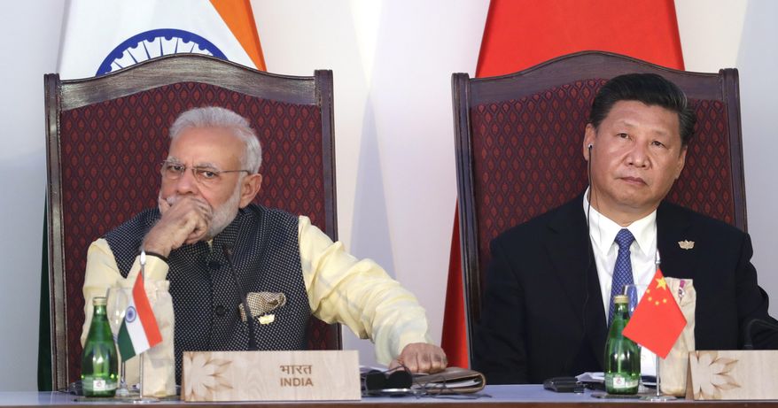 FILE - In this Oct. 16, 2016, file photo, Indian Prime Minister Narendra Modi, left, and Chinese President Xi Jinping listen to a speech during the BRICS Leaders Meeting with the BRICS Business Council in Goa, India. India and China have faced off frequently since fighting a bloody 1962 war that ended with China seizing control of some territory. India’s army chief warned in July 2017 that India’s army was capable of fighting “2 1/2 wars” if needed to secure its borders. The dispute was discussed briefly without resolution by Xi and Modi on the sidelines of the G-20 summit in Hamburg, Germany. (AP Photo/Manish Swarup, File)