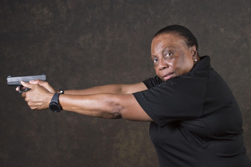 In this July 10, 2017, photo, Lois Woods, an investigator with a career in law enforcement, poses for a portrait in Decatur, Ga., holding her Glock firearm. Woods is a firearms instructor and among the ranks of the nation's black women who own a firearm. She decided to become an instructor after going through the academy and encountering an instructor whose approach did more to instill fear than inspire her to be a good shooter. She now teaches at a range in metro Atlanta. It used to be rare to see a black woman at the range, she said. "When they come in and I'm walking out and they see my shirt (with the range emblem), they look at me with amazement," Woods said. Self-protection is the overwhelming reason she hears most women cite for learning how to shoot. "The fear of being a victim outweighs everything else," Woods says. (AP Photo/Lisa Marie Pane)