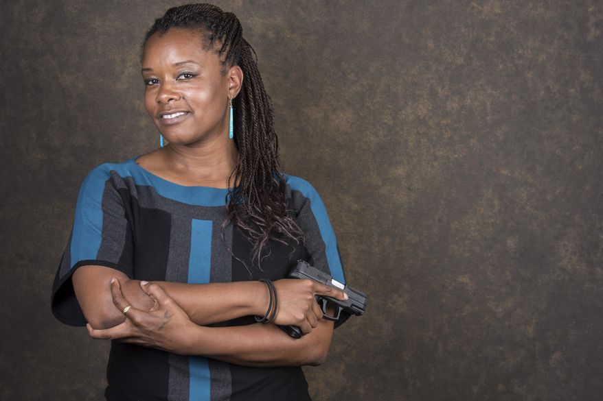 In this July 5, 2017, photo, Markysha Carter poses for a portrait in Decatur, Ga., with her Taurus PT111 handgun. Carter, a 40-year-old marketing specialist for a bank. Carter is among the ranks of the nation's black women who own a firearm. She started taking classes but each time, "the nervous jitters" would creep in. Then about a month ago, she decided to buy a firearm for protection. She worries about remaining safe should she ever be stopped by a police officer. "As a black person in America, this is a major problem," she said. "You hope and pray you're following all the rules and that officer stopping you is following all the rules and doesn't have an agenda." (AP Photo/Lisa Marie Pane)