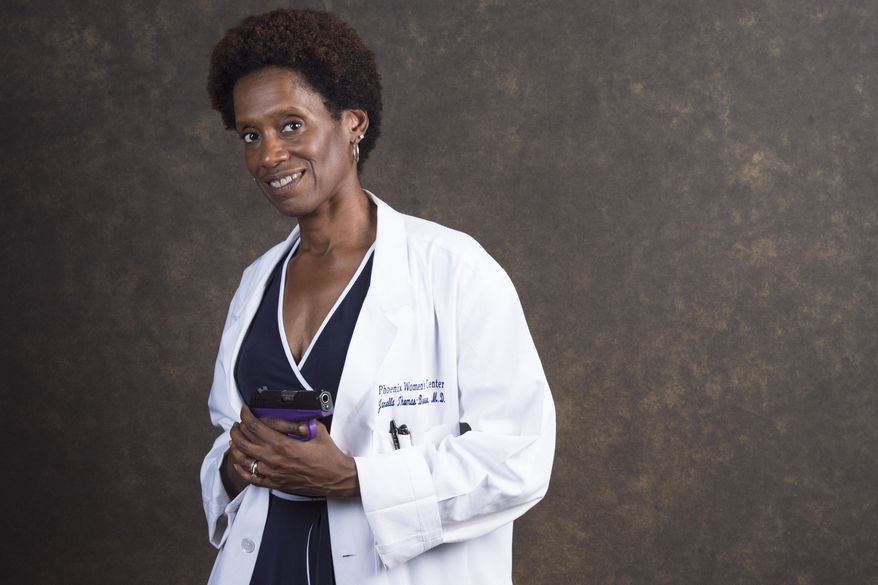In this July 19, 2017, photo, Dr. Janella Thomas-Burse, a 53-year-old gynecologist, poses with her SCCY 9mm handgun. She's among the ranks of the nation's black women who own a firearm. She only recently purchased a firearm, deciding to get one for self-protection. "It just seemed like it was a no-no and so dangerous," she said of owning one. "I like it but I don't get that adrenaline rush like a lot of folks. I'm still working with the comfort level." (AP Photo/Lisa Marie Pane)