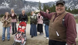 FILE - In this April 21, 2008, file photo, Winston Blackmore, the religious leader of the controversial polygamous community of Bountiful located near Creston, British Columbia, Canada, shares a laugh with six of his daughters and some of his grandchildren. Blackmore has been convicted of practicing polygamy after a decades-long legal fight. Blackmore was found guilty Monday, July 24, 2017, by British Columbia Supreme Court Justice Sheri Ann Donegan. (Jonathan Hayward/The Canadian Press, via AP, File)