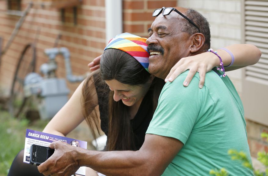 Democratic nominee for the House of Delegates 13th district seat, Danica Roem, gets a hug from supporter and local resident, Godfrey Wade, as she canvasses a neighborhood Wednesday, June 21, 2017, in Manassas, Va. Roem, who was an experienced local newspaper reporter, talks openly about her gender identity but has made jobs, traffic and teacher pay the focus of her campaign. (AP Photo/Steve Helber)