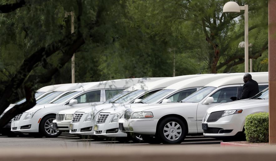 Hearses of the family members who were killed in a flash flood are parked outside St. Patrick church, Tuesday, July 25, 2017, in Scottsdale, Ariz. Ten members of an extended Arizona family were killed earlier this month in flash flood while they celebrated a birthday are being remembered as hard-working immigrants from Mexico trying to provide a better life for their children. (AP Photo/Matt York)