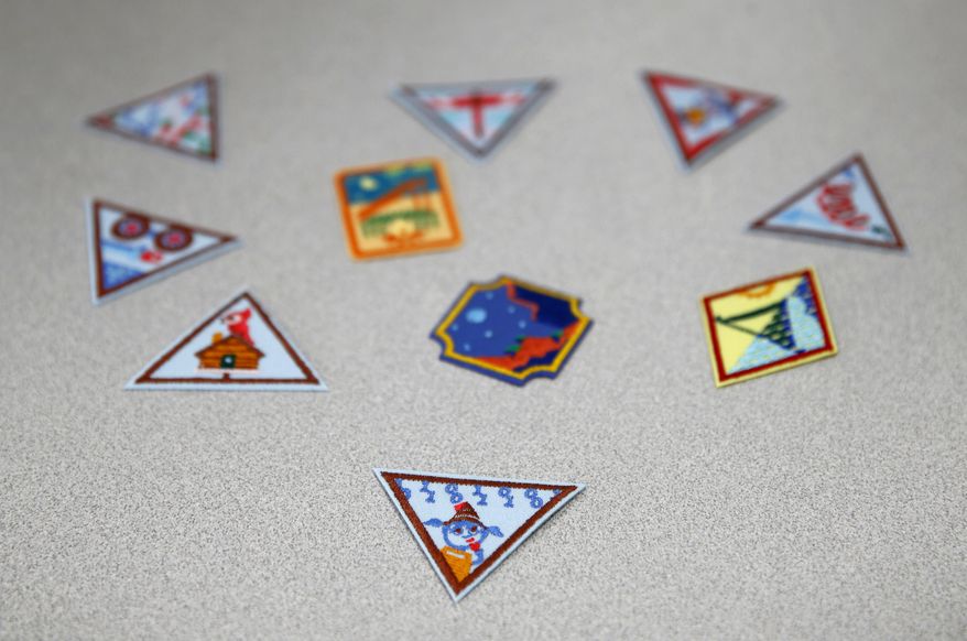 In this July 21, 2017 photo, a Girl Scout badge for learning how to program a robot is seen beneath a sample of new badges focused on science, technology, engineering and math in Owings Mills, Md. The new group of 23 badges takes a progressive approach to STEM and also nudges girls to become citizen scientists using the great outdoors as their laboratory. (AP Photo/Patrick Semansky)