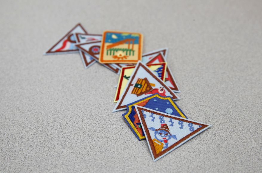 In this July 21, 2017 photo, a Girl Scout badge for learning how to program a robot is seen atop a sample of new badges focused on science, technology, engineering and math in Owings Mills, Md. The new group of 23 badges takes a progressive approach to STEM and also nudges girls to become citizen scientists using the great outdoors as their laboratory. (AP Photo/Patrick Semansky)