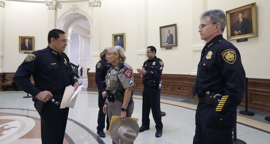 Houston Police Chief Art Acevedo, left, and San Antonio Police Chief William McManus, right, stand with other law enforcement in the rotunda at the Texas Capitol as they wait to speak against a proposed "bathroom bill" at a public safety event, Tuesday, July 25, 2017, in Austin, Texas. The Texas Senate has revived a bill mandating transgender Texans use public restrooms corresponding to their birth-certificate genders. (AP Photo/Eric Gay)