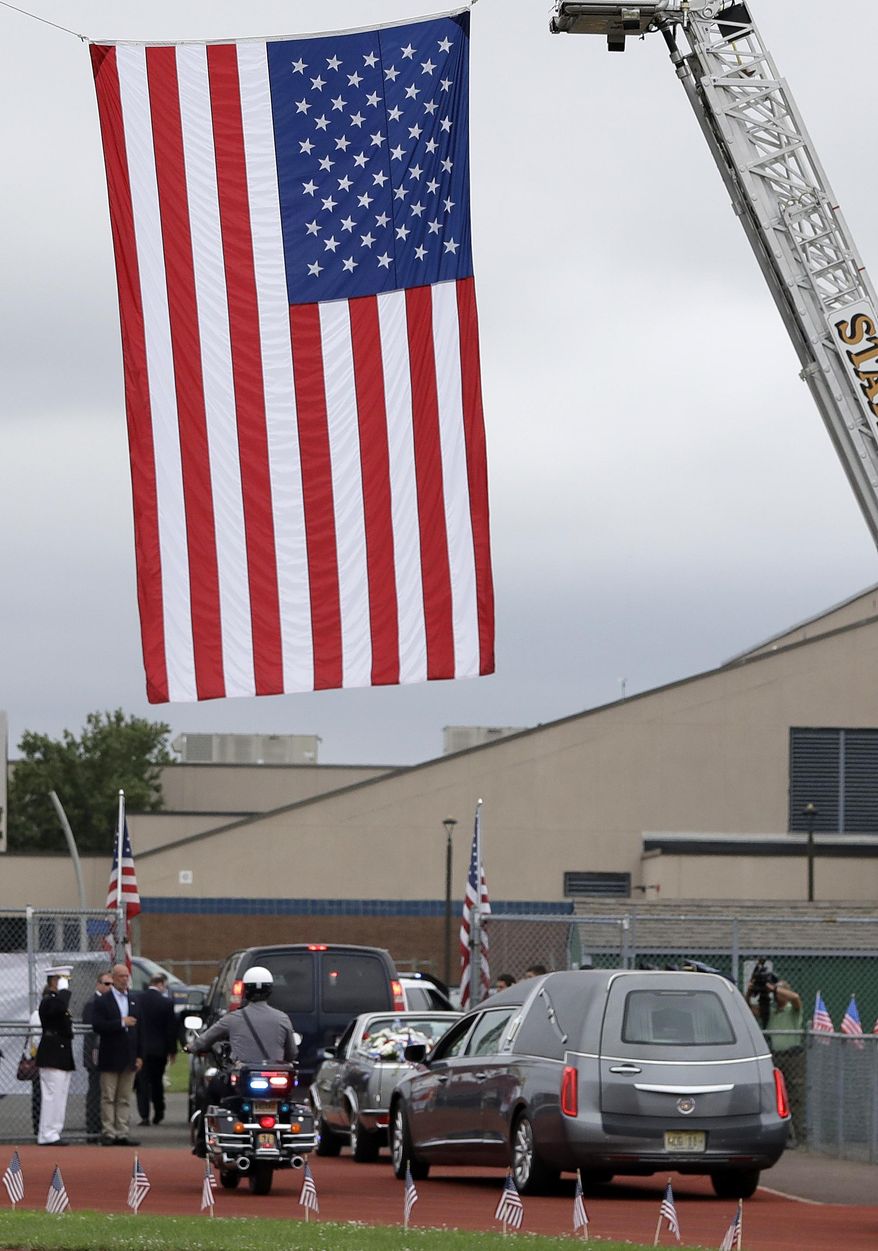 A funeral procession for U.S. Marines Cpl. Dan Baldassare, a Marine killed in a military plane crash in Mississippi, exits the Colts Neck High School football field following funeral services, Tuesday, July 25, 2017, in Colts Neck, N.J. Baldassare was among 15 Marines and a Navy sailor who died when the military transport plane slammed into soybean fields in the Mississippi Delta on July 10. Baldassare had graduated from the school in 2015 and played on its football team for four years. (AP Photo/Julio Cortez)