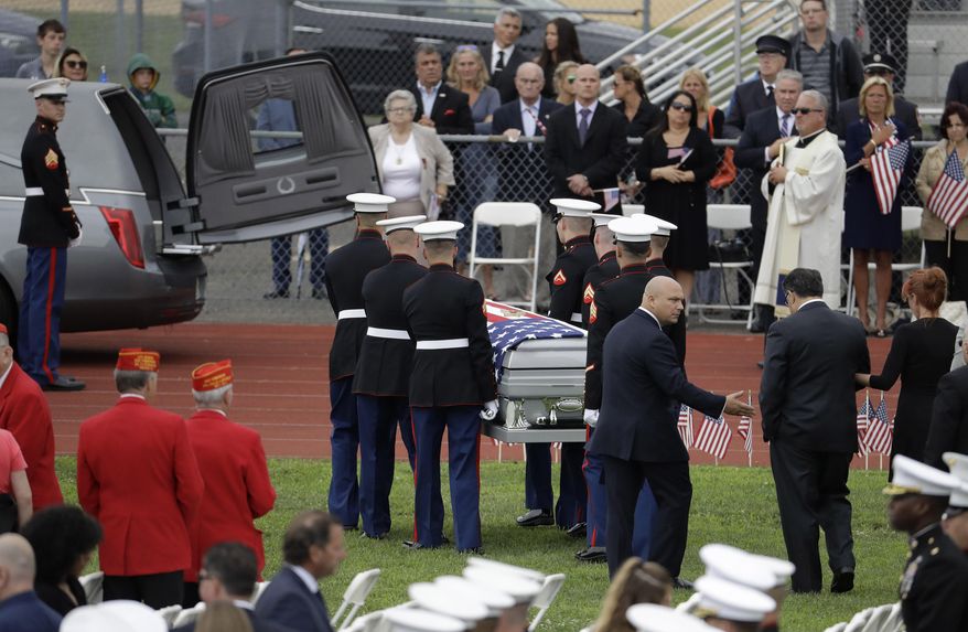 U.S. Marines carry the casket containing the body of Cpl. Dan Baldassare, a Marine killed in a military plane crash in Mississippi, during funeral services for Baldassare at the Colts Neck High School football field, Tuesday, July 25, 2017, in Colts Neck, N.J. Baldassare was among 15 Marines and a Navy sailor who died when the military transport plane slammed into soybean fields in the Mississippi Delta on July 10. Baldassare had graduated from the school in 2015 and played on its football team for four years. (AP Photo/Julio Cortez)