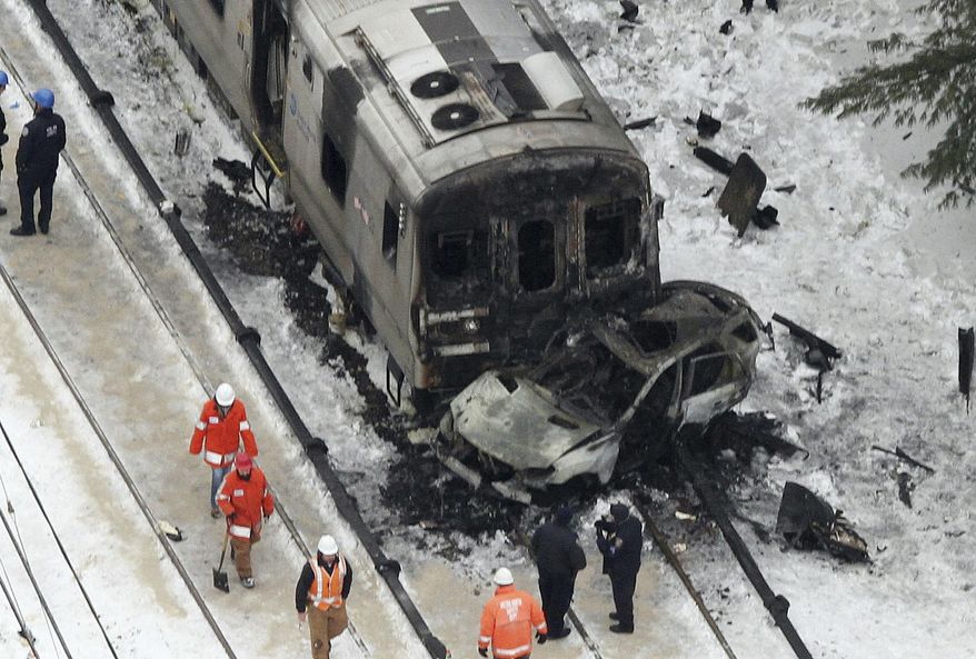 FILE - In this Feb. 4, 2015 photo, workers survey the scene of a deadly commuter train accident in Valhalla, N.Y., in which a packed Metro-North Railroad train slammed into a SUV stuck on the tracks and erupted into flames. Federal investigators have concluded that the fiery crash was extra deadly because of an unusual rail design, a U.S. official told The Associated Press on Monday, July 24, 2017. (Frank Becerra Jr./The Journal News via AP, File)