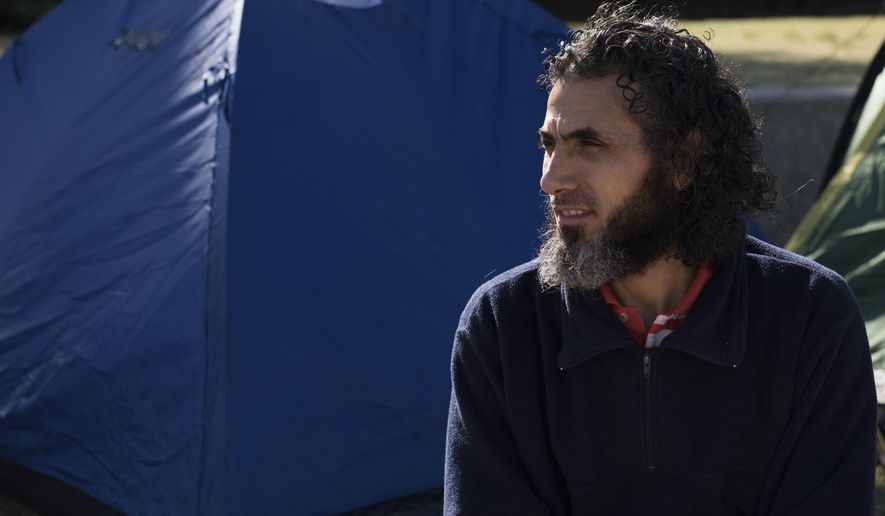 FILE - In this May 5, 2015 file photo, Abu Wa'el Dhiab, from Syria, sits in front of the U.S. embassy while visiting former fellow detainees demanding financial assistance from the U.S., in Montevideo, Uruguay. Authorities reported on Monday, July 24, 2017, that Dhiab has returned to Uruguay after being deported from Morocco. (AP Photo/Matilde Campodonico, File)