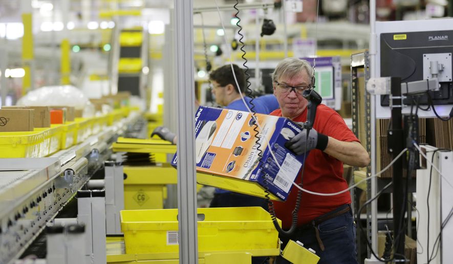 FILE - In this Monday, Nov. 30, 2015, file photo, Mark Oldenburg processes outgoing orders at Amazon.com's fulfillment center in DuPont, Wash. On Wednesday, July 26, 2017, Amazon said that it’s looking to fill more than 50,000 positions across its U.S. fulfillment network. It’s planning to make thousands of job offers on the spot during its first Jobs Day on Aug. 2, where potential employees will have a chance to see what it’s like to work at Amazon by visiting one of 10 participating fulfillment centers. (AP Photo/Ted S. Warren, File)