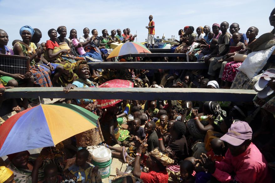 FILE - In this Saturday, May 23, 2015 file photo, refugees who fled Burundi's violence and political tension sing in a speedboat taking them to a ship freighted by the UN, at Kagunga on Lake Tanganyika, Tanzania. Hundreds of people have been killed and hundreds of thousands have fled the small East African nation in the two years since President Pierre Nkurunziza set off protests by declaring he would seek another term. (AP Photo/Jerome Delay, File)