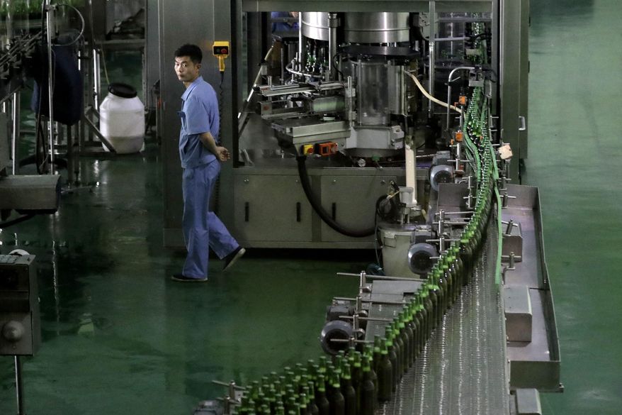 In this Wednesday, July 26, 2017, photo, a worker monitors a conveyor belt where bottles of beer are transported at the Taedonggang Brewery in Pyongyang, North Korea. Taedonggang beers are generally reputed to be world-class, which is a matter of national pride among many North Koreans. (AP Photo/Wong Maye-E)