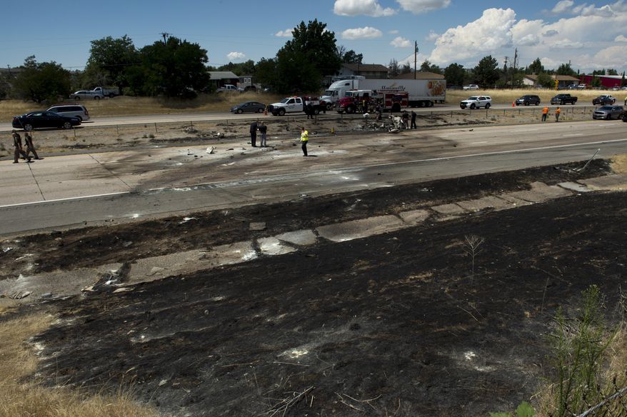 Police investigate the plane crash that killed four people in the median of I-15 near Riverdale, Utah, Wednesday, July 26, 2017. The crash closed the freeway to northbound traffic. (Rick Egan/The Salt Lake Tribune via AP)