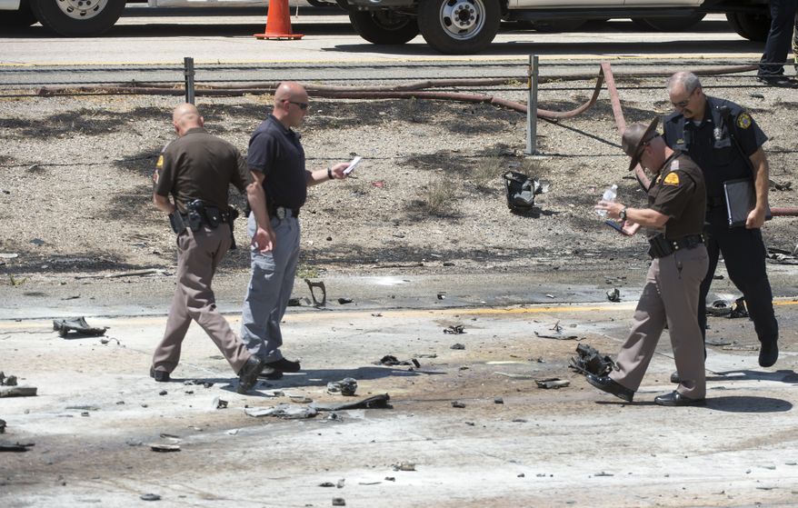 Police sort through the debris from the plane crash that killed four people in the median of I-15 near Riverdale, Utah, Wednesday, July 26, 2017. The crash closed the freeway to northbound traffic. (Rick Egan/The Salt Lake Tribune via AP)