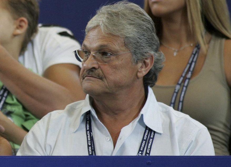 FILE - In this Jan. 3, 2005, file photo, Nikolaos Philippoussis sits in the stands watching his son, Mark Philippoussis, play in the Hopman Cup tennis tournament in Perth, Australia. A San Diego County sheriff's official says the father of a retired Australian tennis star has been arrested on suspicion of molesting two children, the San Diego Union-Tribune reports. The newspaper says Nikolaos Philippoussis, 68, a tennis coach, was taken into custody at his home on Tuesday, July 25, 2017. The Union-Tribune reports that officials said the two victims were under age 14 and were students of Philippoussis. Mark Philippoussis was once ranked eighth in the world. (AP Photo/Mark Ralston, File )