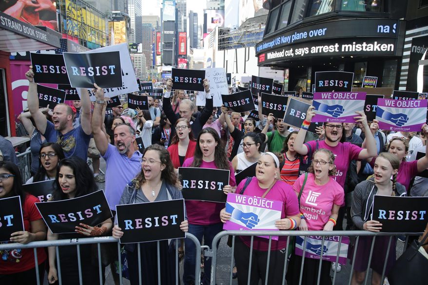 Protestors gather in Times Square, Wednesday, July 26, 2017, in New York. President Donald Trump declared a ban Wednesday on transgender troops serving anywhere in the U.S. military, catching the Pentagon flat-footed and unable to explain what it called Trump's "guidance." His proclamation, on Twitter rather than any formal announcement, drew bipartisan denunciations and threw currently serving transgender soldiers into limbo. (AP Photo/Frank Franklin II)
