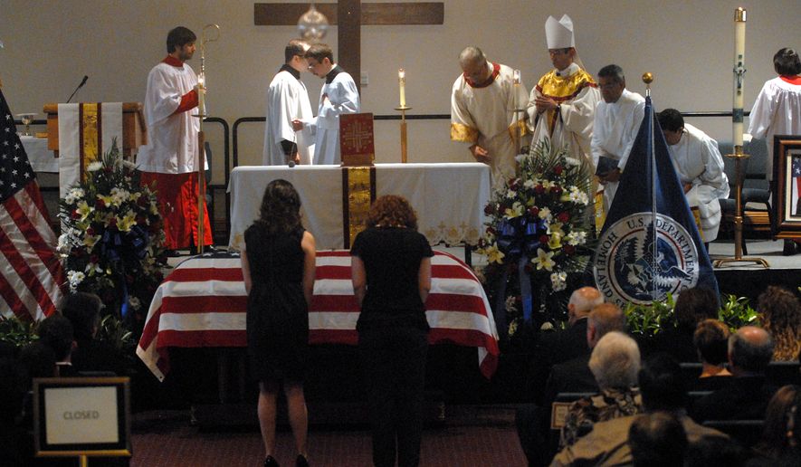 Two women bow before the casket of slain Immigration and Customs Enforcement (ICE) Special Agent Jaime Zapata during a funeral mass at the Brownsville Special Events Center in Brownsville Texas Tuesday, Feb. 22, 2011. Zapata, 32, was run off the road and gunned down in San Luis Potosi state in Mexico on Feb. 15. (AP Photo/Brad Doherty, Pool)