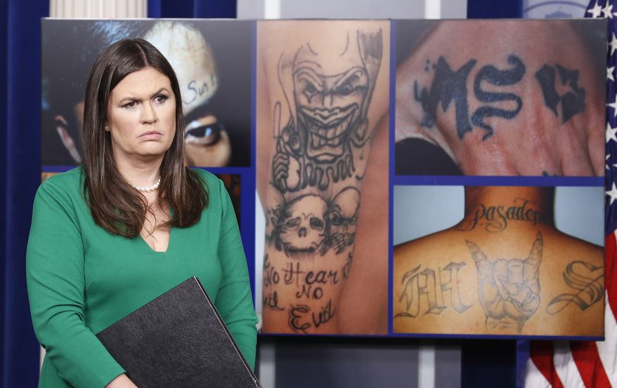 White House press secretary Sarah Huckabee Sanders stands in front of pictures of MS-13 gang tattoos during a press briefing at the White House in Washington, Thursday, July 27, 2017. (AP Photo/Alex Brandon)