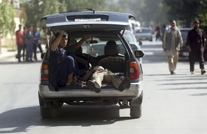 FILE - In this Monday, July 24, 2017 file photo, A wounded man is carried on the way to a hospital near the site of a suicide attack in Kabul, Afghanistan. In the last week the Taliban have overrun two districts in the north and west of Kabul, temporarily cut a key highway linking the capital to the north and staged a suicide bombing in the heart of the capital Kabul. (AP Photos/Massoud Hossaini, File)