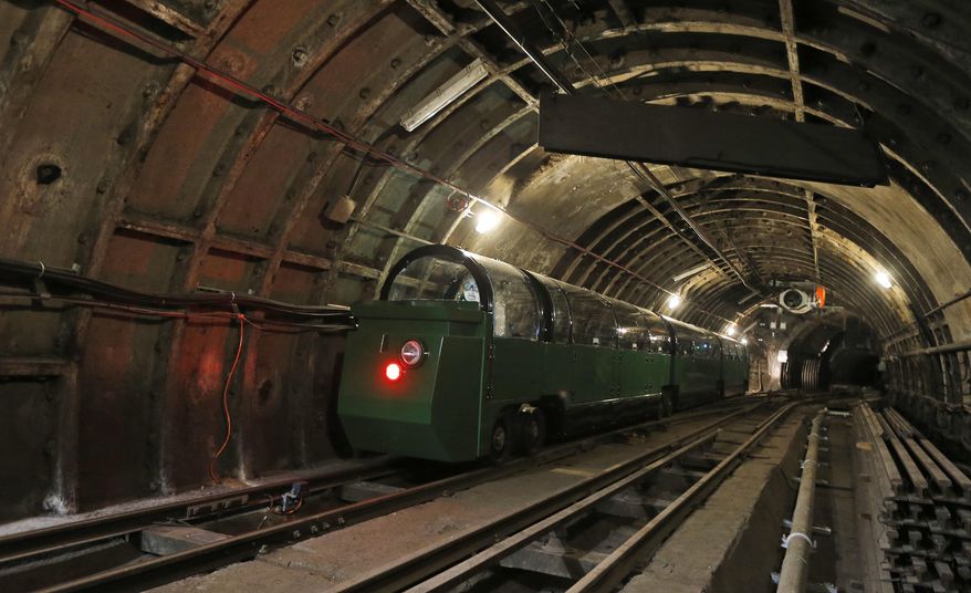 A passenger train rides through the Mail Rail tunnels that is included in the Postal Museum in London, Wednesday, July 26, 2017. London's newest tourist attraction is perfect for underground explorers. It's not ideal for the claustrophobic. A visit to Mail Rail, a subterranean train network that once carried millions of letters a day across the city, involves a cramped journey through dark tunnels 70 feet (21 meters) below the surface, on a very small train. It's atmospheric, but not roomy. (AP Photo/Frank Augstein)