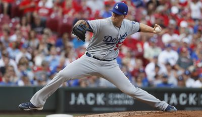 FILE - In this June 16, 2017, file photo, Los Angeles Dodgers starting pitcher Alex Wood throws in the first inning of a baseball game, enroute to a 3-1 win against the Cincinnati Reds, in Cincinnati. With Clayton Kershaw sidelined by injury, the Dodgers are in need of a dominant left-hander. Baseball’s best team need look no farther than one locker past Kershaw’s in the clubhouse. Alex Wood has been doing his best impression of the three-time NL Cy Young Award winner for the last several weeks. (AP Photo/John Minchillo, File)