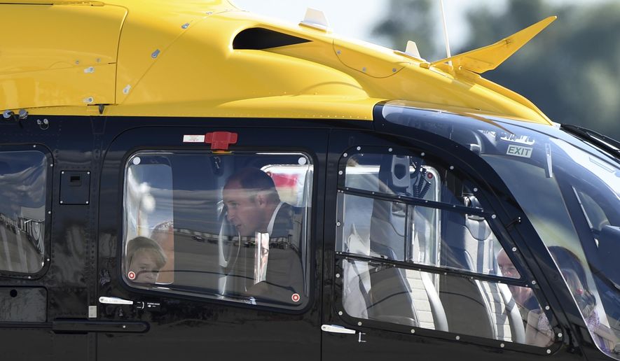 Great Britain's Prince William looks at the interior of a Airbus helicopter with his son Prince George in Hamburg, Germany, Friday, July 21, 2017. Hamburg is the last leg of the royal couple's Germany visit. (Christophe Gateau/dpa via AP)