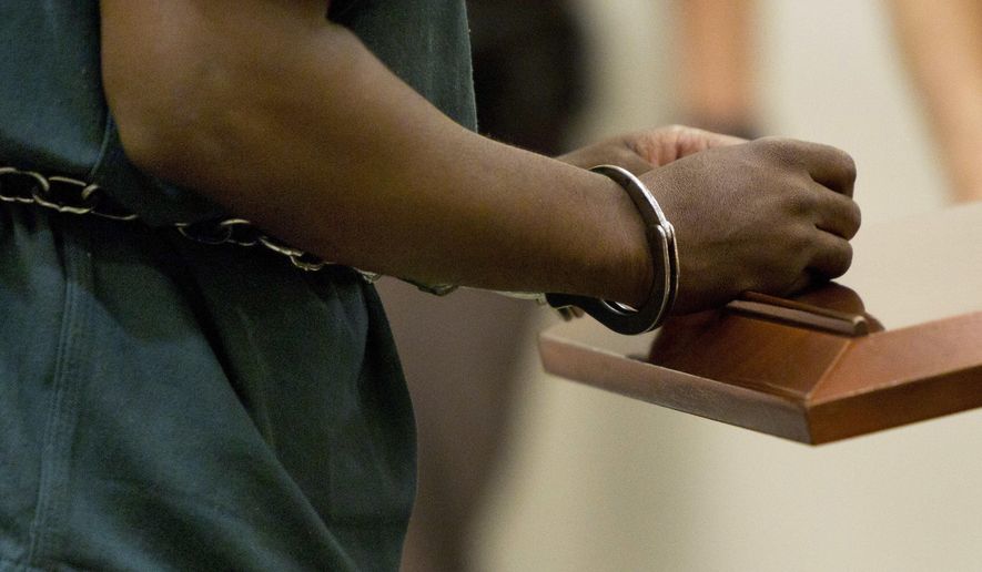 ADVANCE FOR USE MONDAY, JULY 31, 2017 AND THEREAFTER-In this Friday, Sept. 30, 2016 photo, Ahmad Williams wears handcuffs as he appears for his resentencing hearing at the Kent County Courthouse in Grand Rapids. Williams, who was convicted in the 1988 fatal shooting of Derrick Pimpleton, is one of several "juvenile lifers" to be resentenced because of Supreme Court rulings that ended mandatory no-parole sentences for crimes committed by juveniles. (Cory Morse/The Grand Rapids Press via AP)